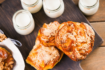 Bread buns, jars with milk on a cutting board 