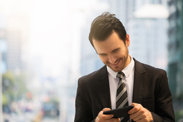 Businessman playing on smart phone