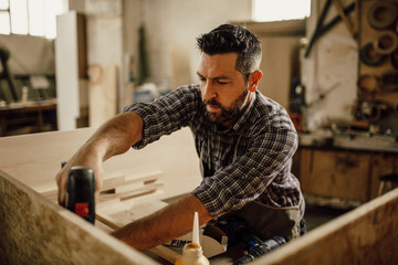 handsome joiner work in carpentry. He is successful entrepreneur at his workplace.