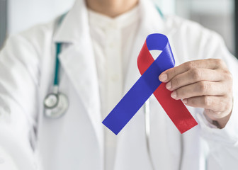 Red Blue ribbon awareness in medical doctor's hand for Congenital Heart Defects disease, Noonan's...