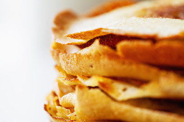 A stack of golden pancakes. Closeup, selective focus
