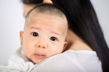 Asian woman holding her baby boy isolated over white background