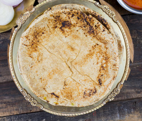 Indian Cuisine Chapati Also Called Roti, Flatbread, Chapathi or Chapatti Served With Sev Tamatar, Gatta Curry, Raita, Papad or Onion on Wooden Background