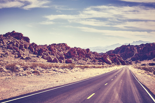 Retro toned desert road, travel concept, Valley of Fire; Nevada, USA.
