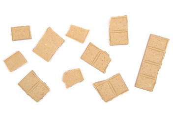 White nougat chocolate bar pieces with hazelnuts isolated on white background, top view