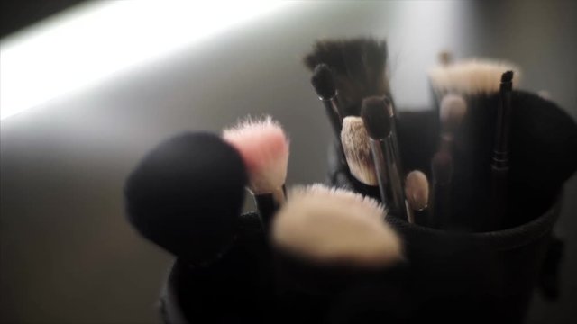 Set of brushes for make-up on table in dressing room.