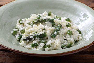risotto con asparagi tradizionale italiano su sfondo tavolo di cucina rustico