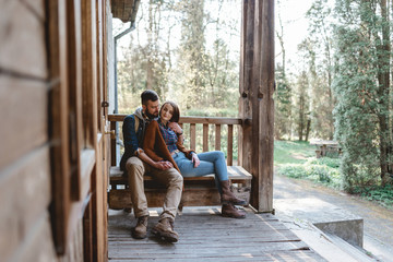 young couple hipster sitting on a bench on the terrace