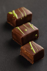 Cut chocolate praline candy on black background