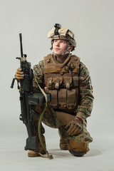 Soldier in camouflage holding rifle