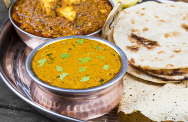 Indian Traditional Thali Food Dal Makhani Served with Chapati, Papad, Kadai Paneer or Lemon Also Know as Dal Makhni or Daal Makhani is a Popular Dish From Punjab. on Vintage Wooden Background