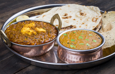 Indian Traditional Thali Food Dal Makhani Served with Chapati, Papad, Kadai Paneer or Lemon Also Know as Dal Makhni or Daal Makhani is a Popular Dish From Punjab. on Vintage Wooden Background