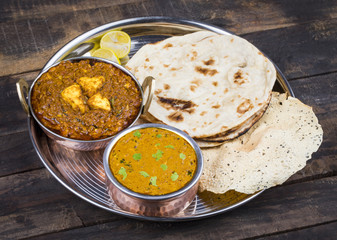 Indian Traditional Thali Food Dal Makhani Served with Chapati, Papad, Kadai Paneer or Lemon Also Know as Dal Makhni or Daal Makhani is a Popular Dish From Punjab. on Vintage Wooden Background