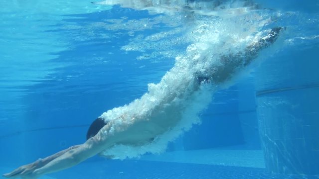 Men swimming underwater in slow motion. Fit body healthy concept.