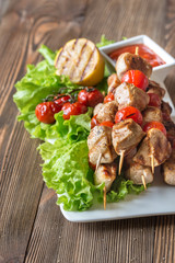 Grilled chicken skewers on the white plate