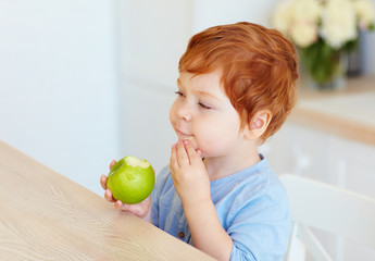 Fototapeta premium cute redhead toddler baby biting tasty green apple