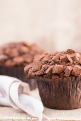 Homemade muffins with chocolate, vintage background.