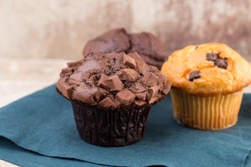 Homemade muffins with chocolate, vintage background.