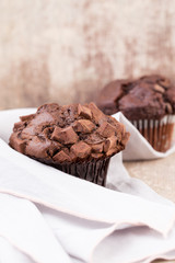 Homemade muffins with chocolate, vintage background.