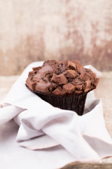 Homemade muffins with chocolate, vintage background.
