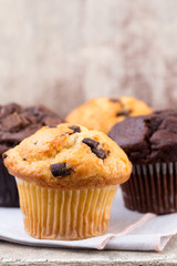 Homemade muffins with chocolate, vintage background.