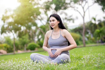 Naklejka na ściany i meble pregnant woman relaxing in the park