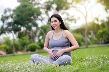 Naklejka na ściany i meble pregnant woman relaxing in the park