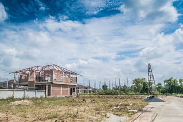 Fototapeta na wymiar Residential new house building at construction site with clouds and blue sky