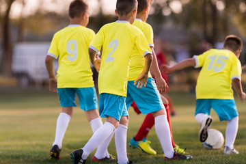 Obraz premium Young children players football match on soccer field