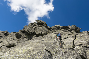 Climbing in the mountains. Climber while climbing a rocky rib on the way to the top.