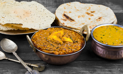 Indian Food Kadai Paneer Served With Dal Makhani, Tandoori or Papad Also Called Kadhai Paneer or Karahi Paneer is an Indian Dish of Marinated Paneer Cheese Served in Spiced Gravy on Wooden Background