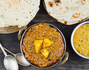 Indian Food Kadai Paneer Served With Dal Makhani, Tandoori or Papad Also Called Kadhai Paneer or Karahi Paneer is an Indian Dish of Marinated Paneer Cheese Served in Spiced Gravy on Wooden Background