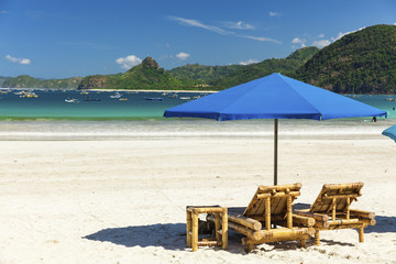 Tropical Balinese beach with white sand, blue water and traditional fishing boats, Lombok