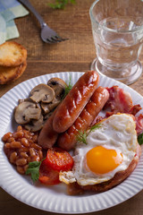 Full English or Irish breakfast on wooden table. Nutritious and healthy morning meal. vertical