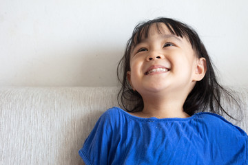 Asian Chinese little girl sitting on the sofa