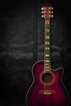 Purple acoustic guitar over dark background