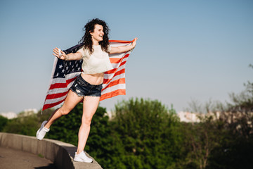 Obraz na płótnie Canvas Girl with an American flag. Independence Day concept