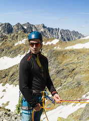 Belayer on the background of a mountain ridge.