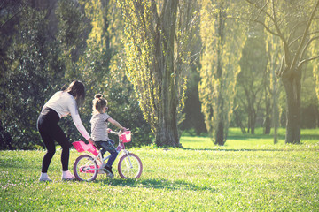 little girl having fun with bike. Learning to ride a bicycle at the park
