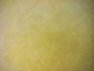 yellow natural stone with typical marble veins, polished surface; close-up
