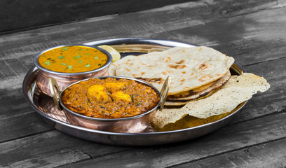 Indian Traditional Thali Food Kadai Paneer Served With Dal Makhani, Tandoori Roti or Papad on Vintage Wooden Background