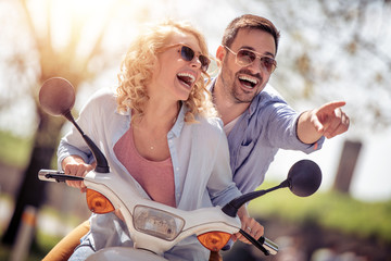Cheerful young couple riding a scooter © ivanko80