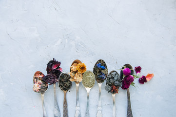 Various flavors of tea. Green tea flower tea matcha karkade in spoons. Flat lay.