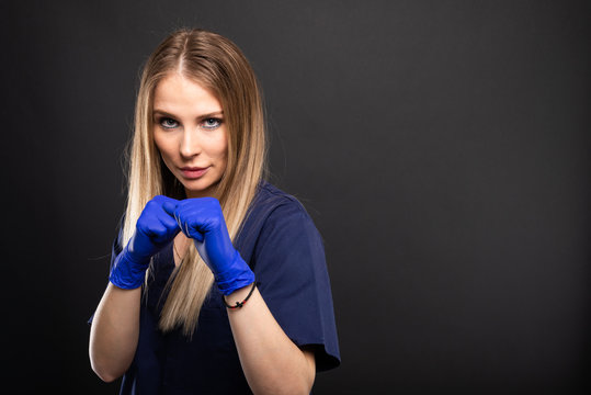 Beautiful female dentist wearing standing in fighting position.