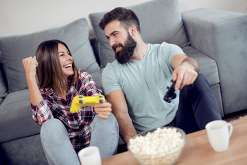 Joyful couple playing video games at home