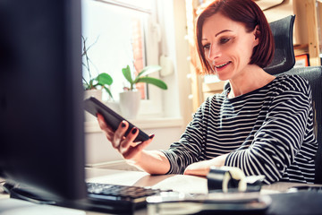 Woman using smart phone at the office