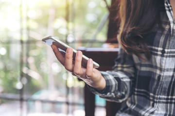 Closeup image of a woman holding , using and looking at smart phone