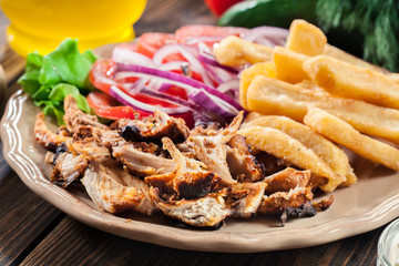Greek gyros dish with french fries and vegetables
