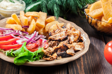 Greek gyros dish with french fries and vegetables