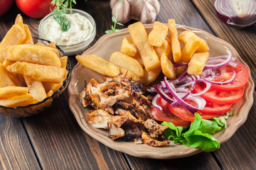 Greek gyros dish with french fries and vegetables